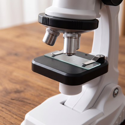 Gros plan des objectifs et de la platine du microscope enfant blanc avec une lame